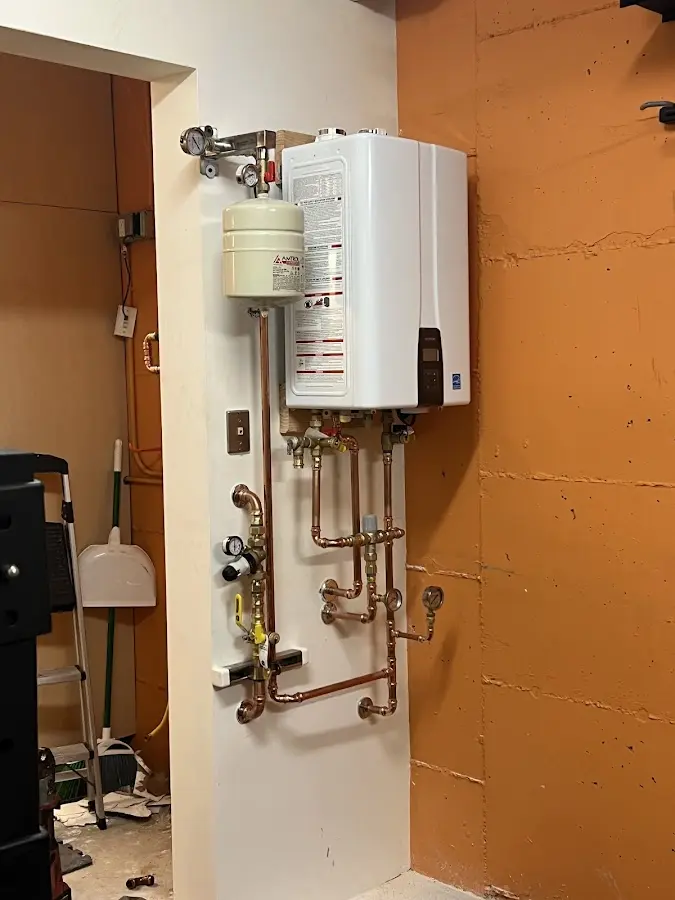 Plumbing technician inspecting water heater connections in Webster City